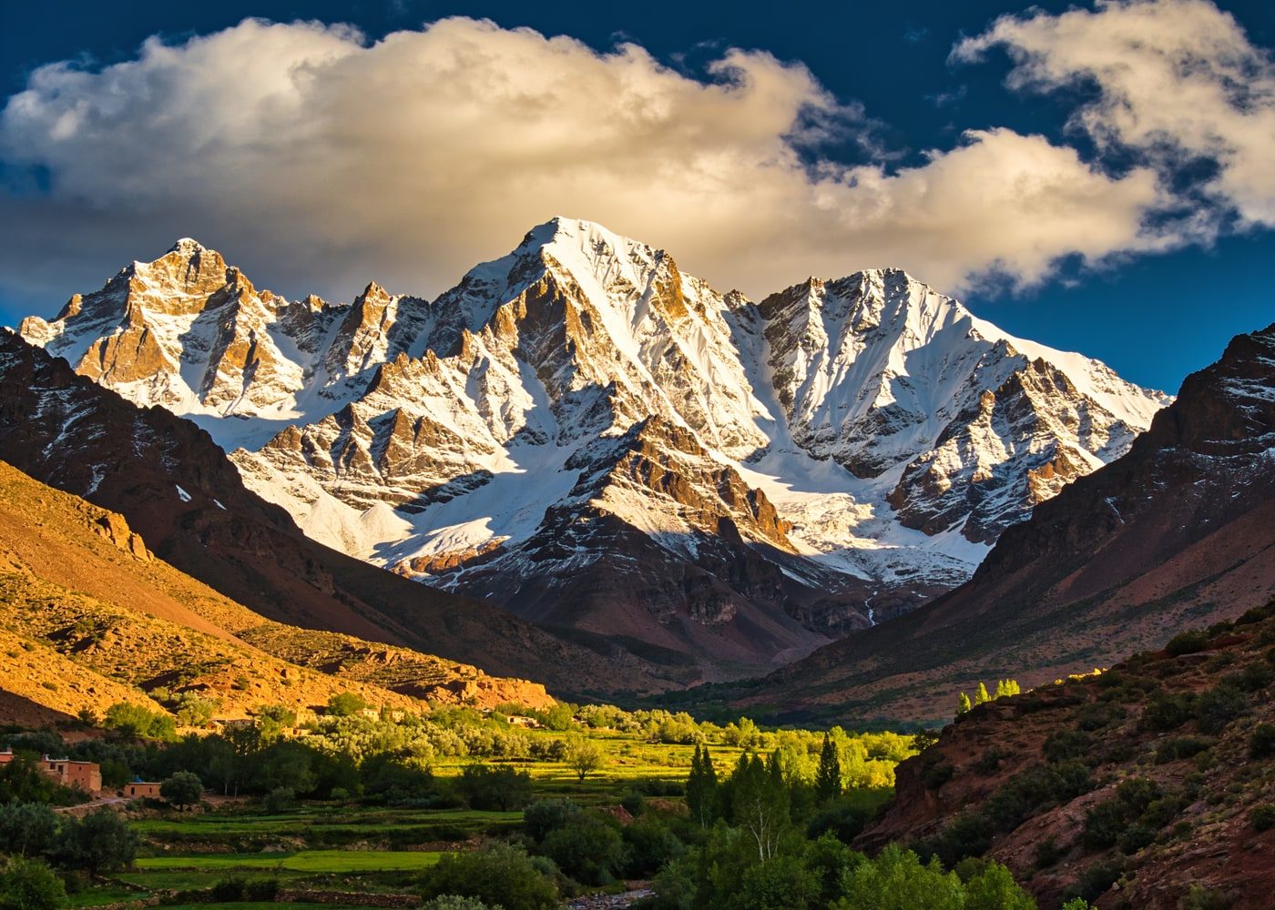 Snow-capped High Atlas mountains above a green valley